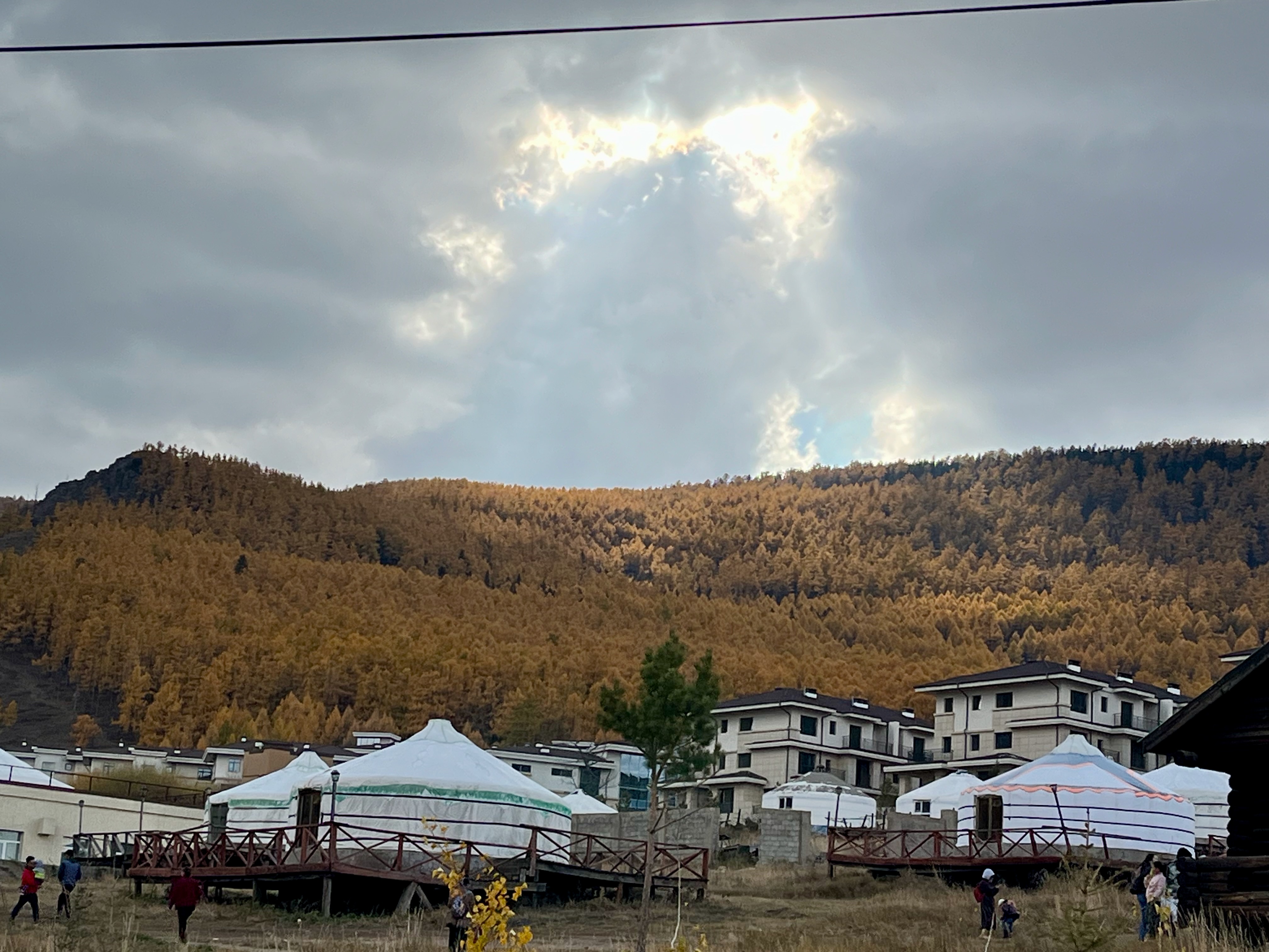 A ray of sunshine casting down into the mountain of trees, in Fall.